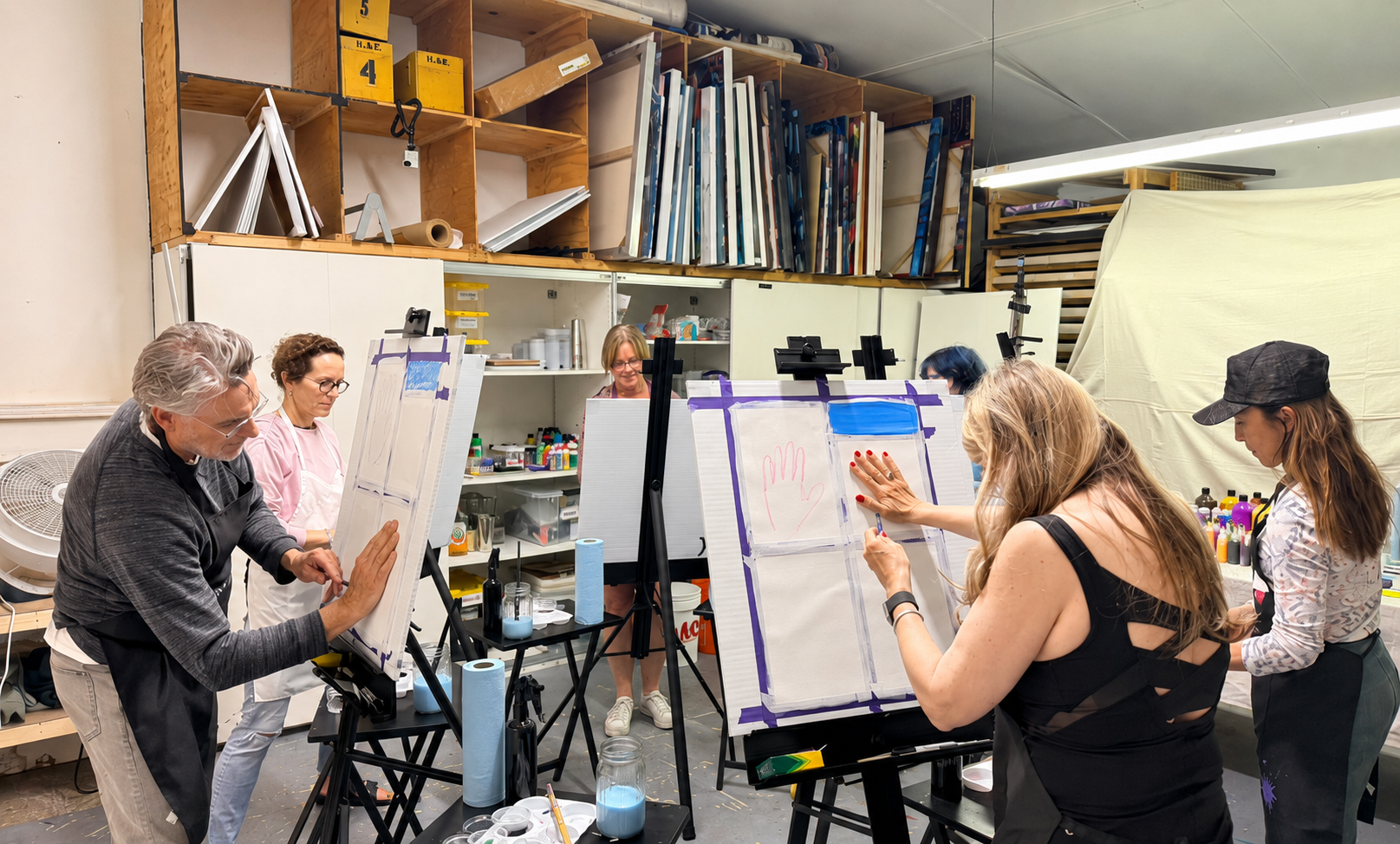 Participants painting together around easels in the Present Wonders studio